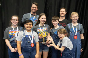 Team Smiling and Showing off their Trophy