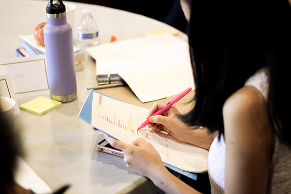 Woman at a table with a list and highlighter